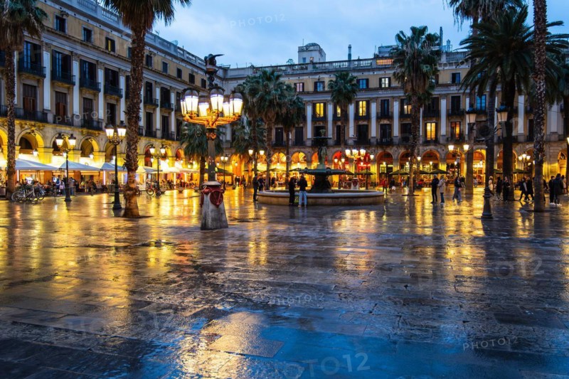 Nightlife at Plaça Reial, lanterns by Gaudi in the historic centre of Barcelona, Spain