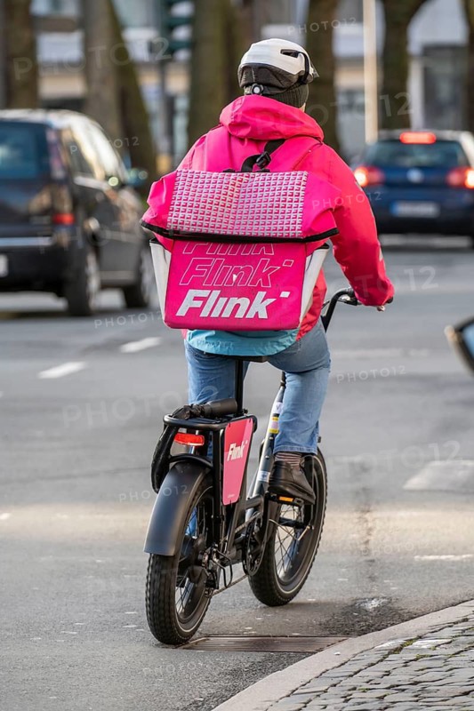 Bicycle courier of the Flink express delivery service, delivers groceries, currently in over 40 German cities, within 10 minutes, orders via an app, works together with the REWE Group, Bochum, North Rhine-Westphalia, Germany