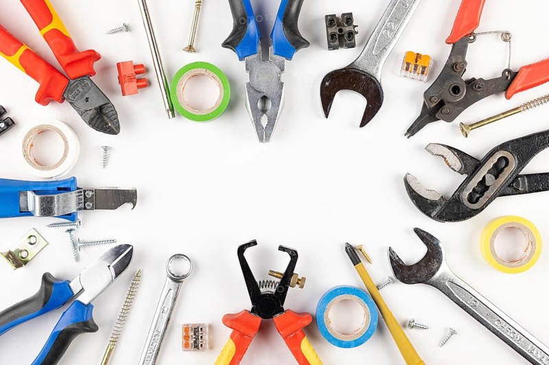 Colorful tools, tape, screws and cable connectors in circle shape on white background