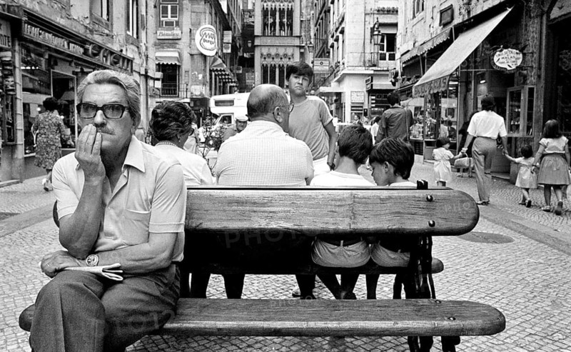 A man sits on a bench in the historic city center of Lisbon, Lisbon, Portugal