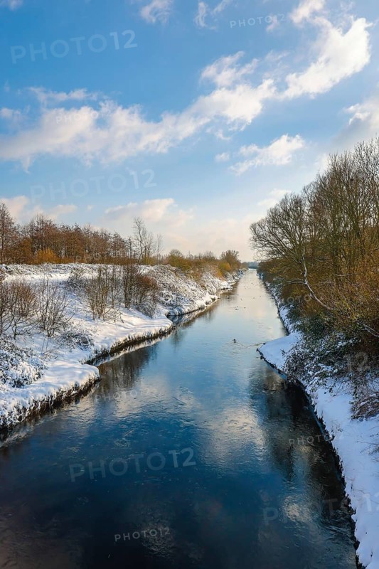 Dortmund, North Rhine-Westphalia, Germany - Sunny winter landscape in the Ruhr area, ice and snow on the renaturalised Emscher, the ecological conversion of the Emscher system consists of the construction of a central wastewater treatment system in the Ruhr area, the construction of underground sewers and the renaturalisation of the Emscher and its tributaries