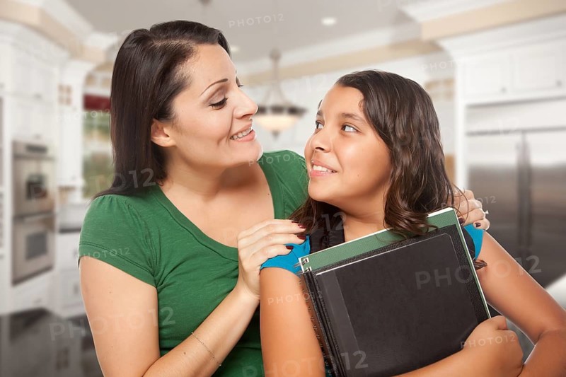 Proud Hispanic Mother and Daughter In Kitchen at Home Ready for School