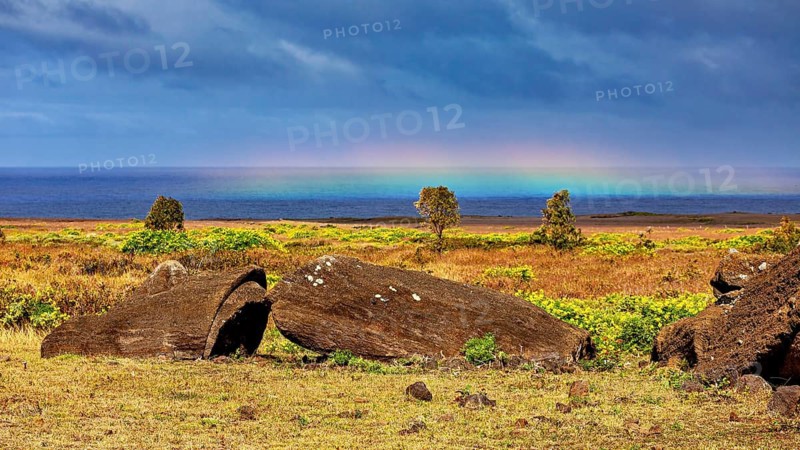 Boulders in a Meadow, a Rainbow Stretching across the Sea, The Moai Statues on Easter Island in the Pacific Ocean