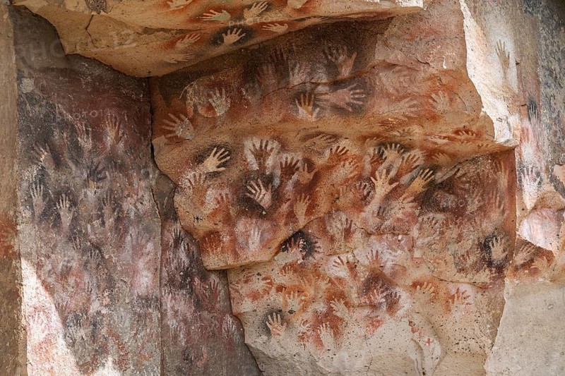 Prehistoric handprints in negative technique on rock wall, cave painting in red, ochre and black, Cueva de las Manos, Río Pinturas, Santa Cruz Province, Argentina