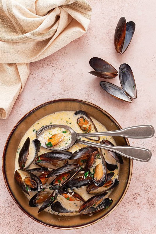 Mussels in creamy garlic sauce, served with fresh herbs and spices, homemade, no people