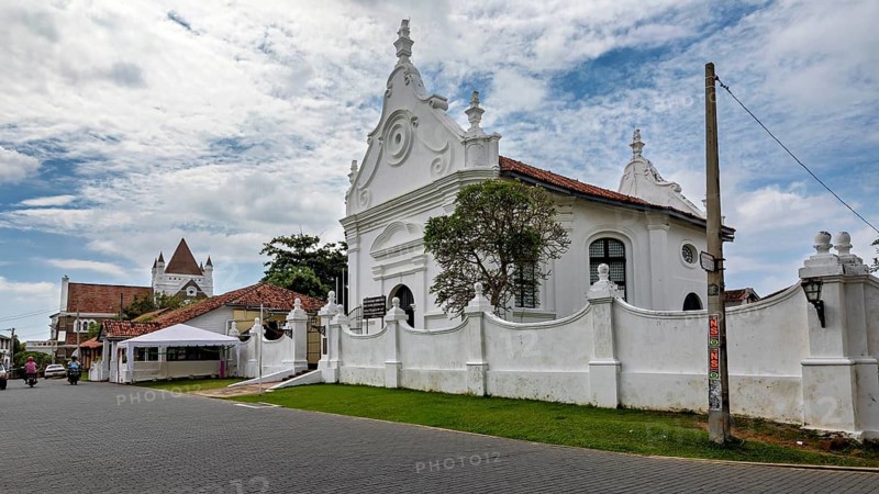 White church with decorative architecture in a historic setting under blue skies, The historic downtown of Galle in Sri Lanka