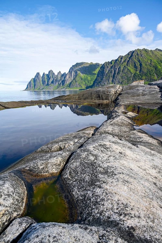 Reflection in a tidal pool, rocky coast of Tungeneset, Devil's Teeth, Okshornan, Ersfjorden, Senja Island, Troms, Norway