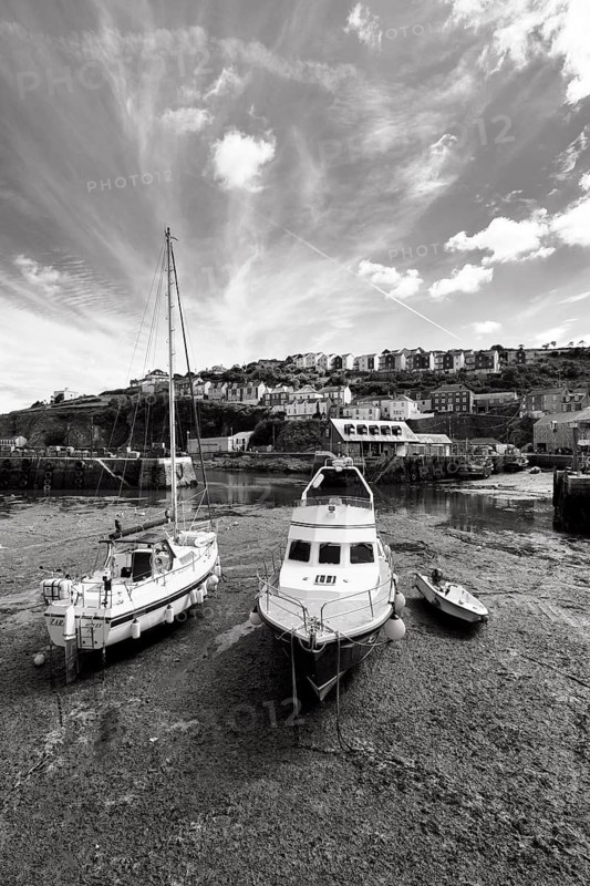 Fishing boats in tidal harbour, low tide, monochrome, Mevagissey, St Austell, Cornwall, England, Great Britain