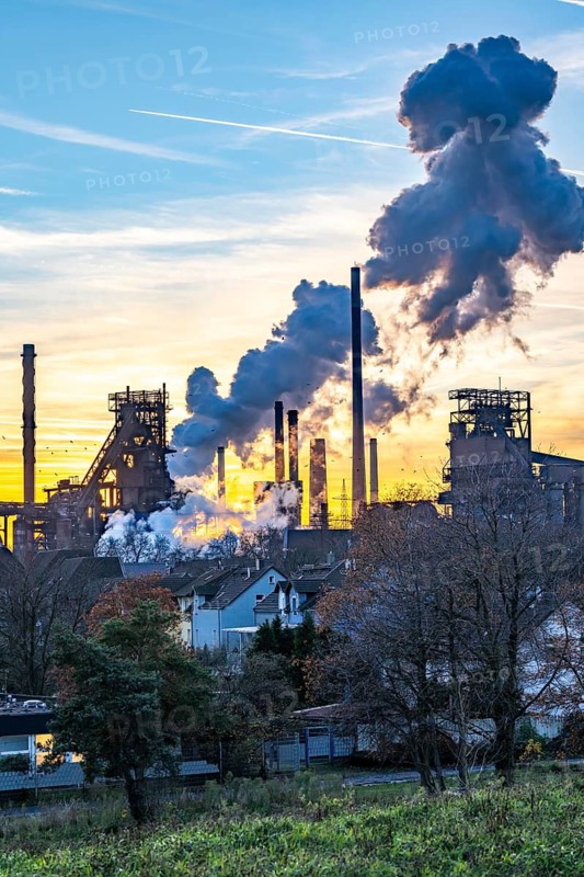 Blast furnace Schwelgern 1 and 2, ThyssenKrupp Steel plant Schwelgern in Duisburg-Marxloh belongs to the Bruckhausen steelworks, extinguishing cloud of the Schwelgern coking plant, sunset, North Rhine-Westphalia, Germany