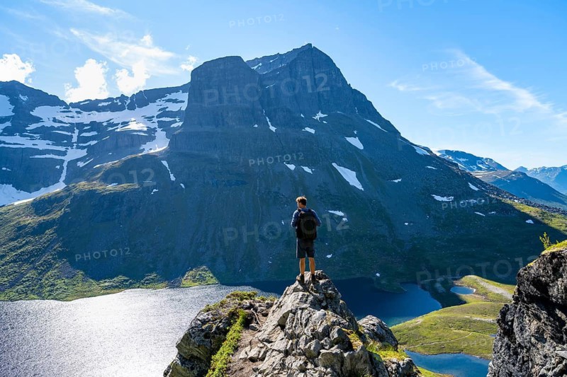 Hiker standing on a rock, view of mountain landscape and lake Giklingdalsvatnet, Flatvaddalen high valley, Innerdalen side valley, Sunndal, Møre og Romsdal, Vestlandet, Norway