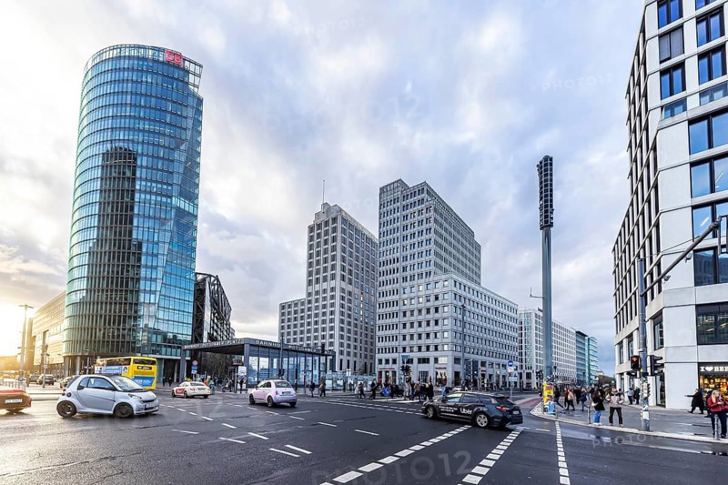 Potsdamer Platz Berlin in the evening with traffic on the streets. When it rains, the skyscrapers are reflected in puddles of water. Bahn-Tower, headquarters of Deutsche Bahn AG. Berlin, Germany