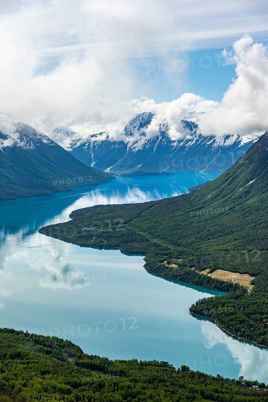View of snowy mountains in spring and turquoise Kenai Lake with reflection, Slaughter Ridge Trail, Cooper Landing, Kenai Peninsula, Alaska, USA