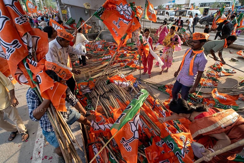 Supporters arrange flags of the Bharatiya Janata Party ahead of a public rally for the Assam Assembly Election 2026 in Guwahati, India on 28 March 2026