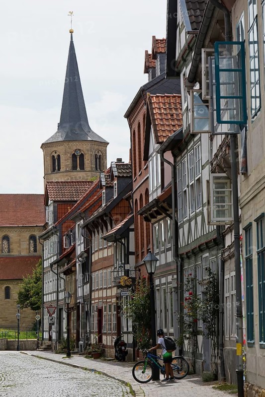 Facades of half-timbered houses in Brühlstrasse with the steeple of the Basilica of St. Godehard, Hildesheim, Lower Saxony, Germany