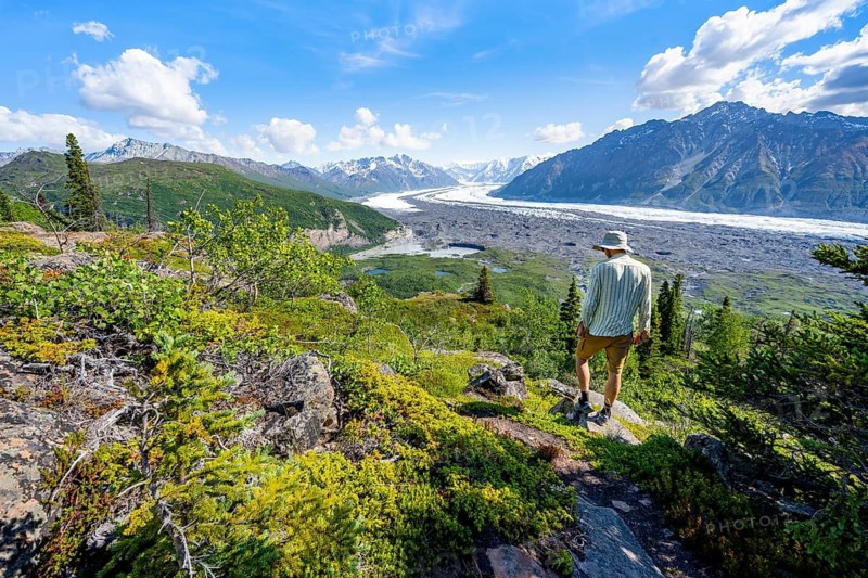 Young man enjoying the view, view of impressive mountain landscape with Matanuska glacier and glaciated mountain peaks, Lion's Head, Chugach Mountains, Alaska, USA