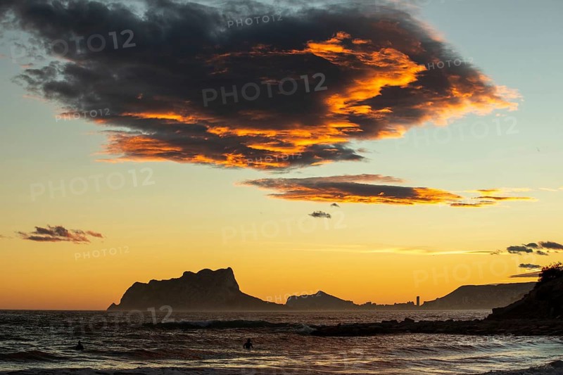 Stunning Mediterranean sunset over Costa Blanca, showcasing a vibrant sky with orange hues reflecting on the sea. A picturesque landscape capturing serene coastal beauty