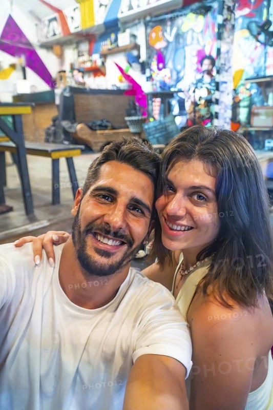 Tourists enjoying their holidays in a vibrant restaurant in siargao island, philippines, capturing a cheerful selfie