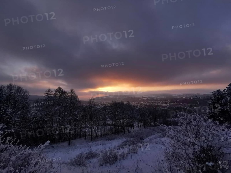 Snowy landscape at sunset with view of Rosenberg Kronach Fortress, Frankenwald nature park Park