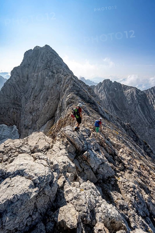Two mountaineers on a rocky narrow mountain path, view of the summit of the Hochkalter, mountain tour to the summit of the Hochkalter, Hochkalter crossing, Berchtesgaden Alps, Bavaria, Germany