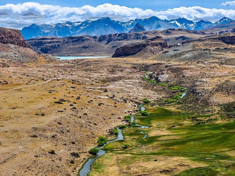 Gravel road ruta 41, Los Antiguos - Paso Roballo, stretch of green along river Columna, aerial view, Argentina
