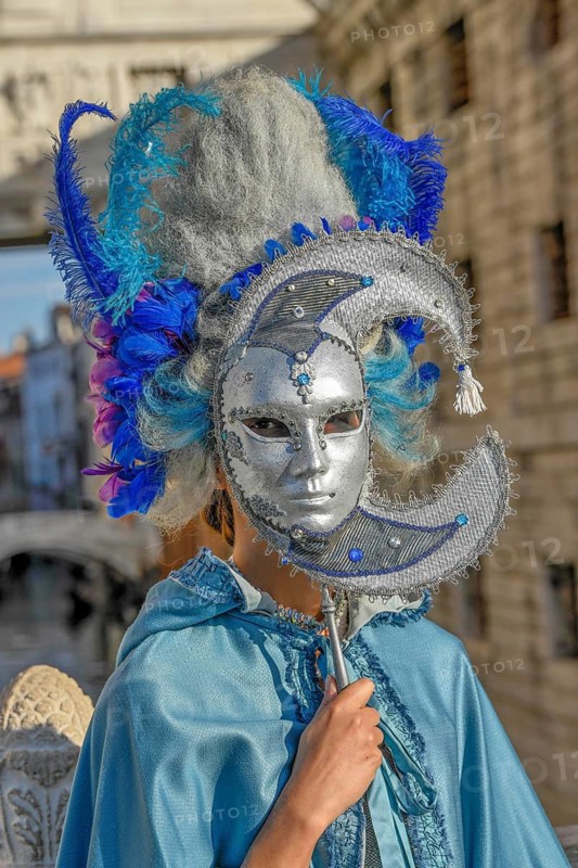 Costumed woman with traditional Venetian mask in front of the Bridge of Sighs, Carnival, Venice, Veneto Region, Italy