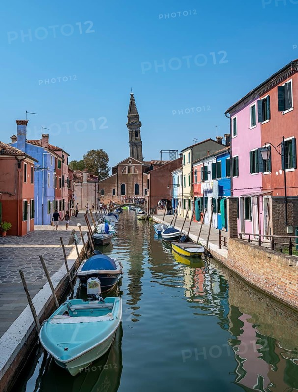 Colourful houses on the canal with reflection, canal with boats and colourful house facades, in the background church tower of the Chiesa Parrocchiale di San Martino Vescovo, Burano Island, Venice, Veneto, Italy