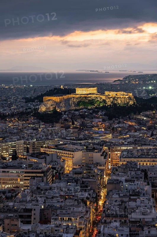 View over the sea of houses of Athens, illuminated Parthenon temple on the Acropolis, from Mount Lycabettus, Athens, Greece