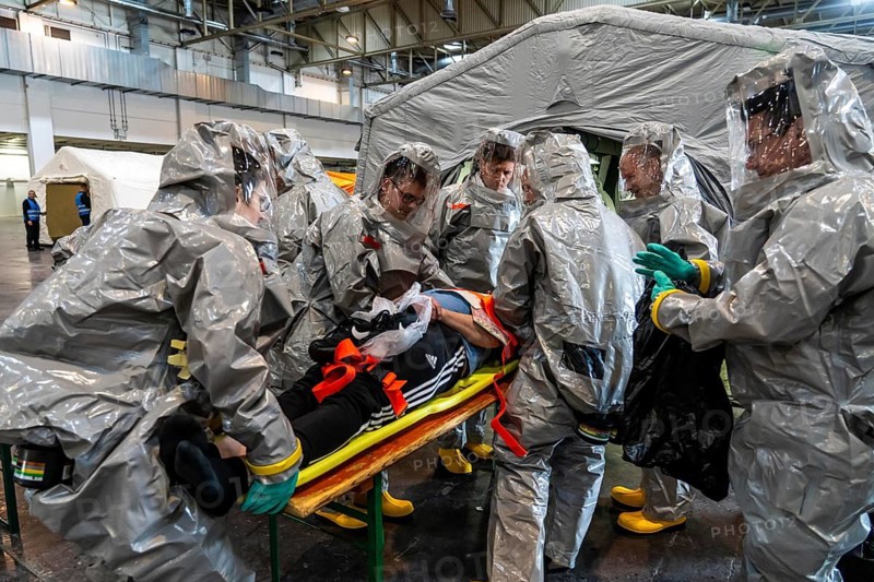 Decontamination of injured persons after an assumed accident involving hazardous substances, fire brigade and aid organisations practise setting up and operating a decontamination station, injured persons are sighted and then washed in a special shower tent to remove possible hazardous substances and chemicals in order to avoid further injuries, the emergency services wear special, ventilated protective suits, large-scale exercise by the Essen fire brigade