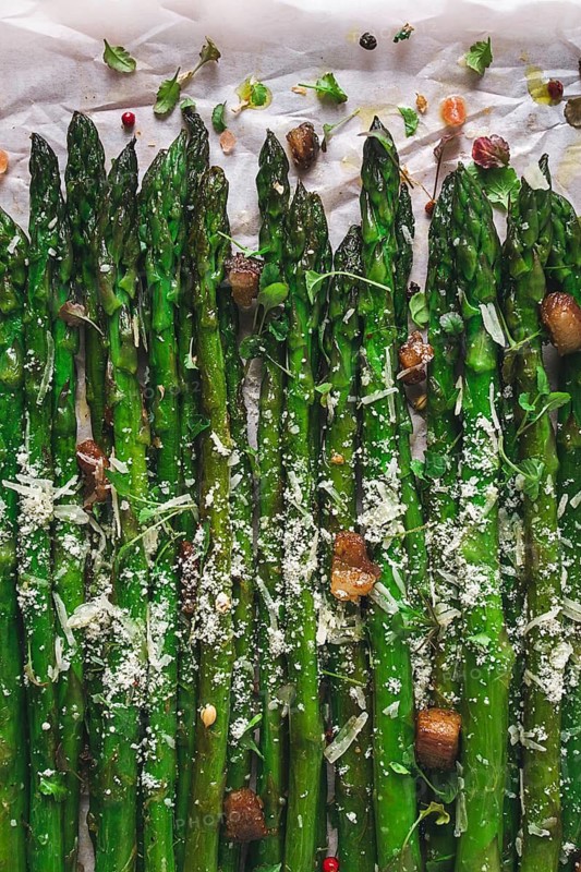 Grilled asparagus, with spices and herbs, parmesan cheese, on a white background, top view, rustic, no people