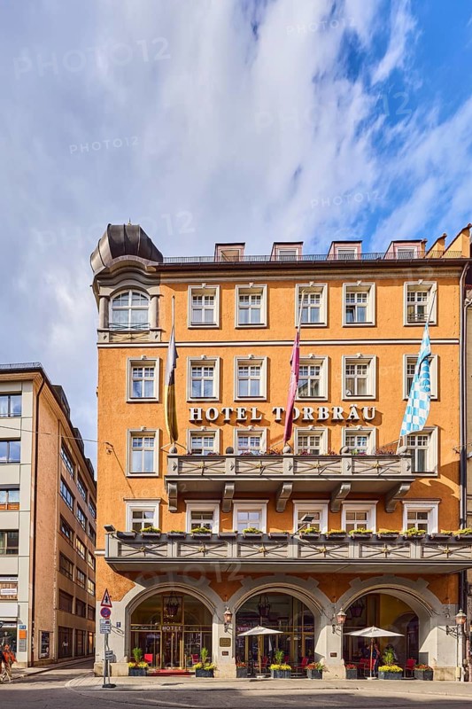 Hotel Torbräu, historic commercial building, German Renaissance style, balcony, dormers, façade with windows, outdoor area of a restaurant, Schapeau restaurant, streets, trees, blue sky, cumulus clouds, Pflugstraße confluence with valley, Munich, state capital, district-free city, Bavaria, Germany
