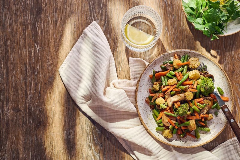 Plate of stir-fried mixed vegetables with green beans, carrots, baby corn, romanesco and mushrooms
