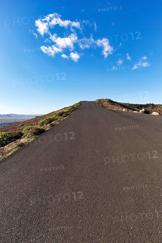 Empty country road leading uphill, Caldera, Guanapay volcano, near Teguise, Lanzarote, Spain