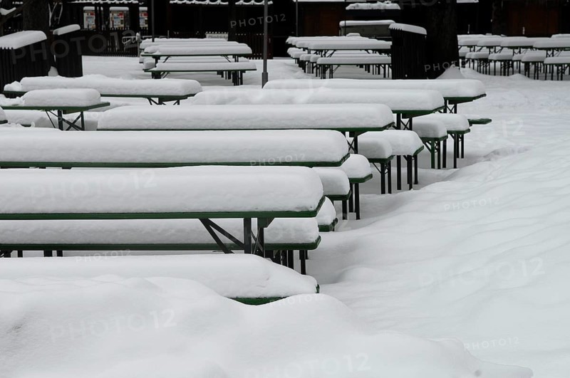 Winter in the English Garden, snow-covered beer garden tables and benches, Munich, Bavaria, Germany