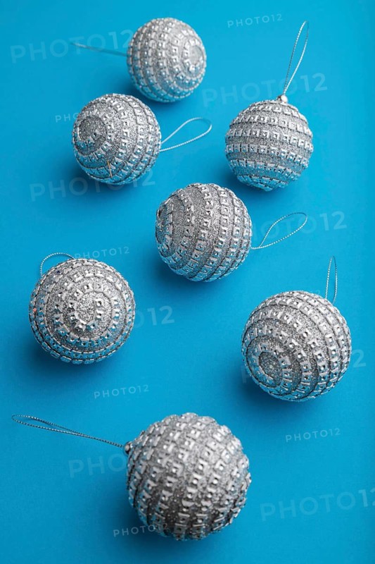 Christmas or New Year composition. Decorations, silver balls, on a blue paper background. Side view, close up
