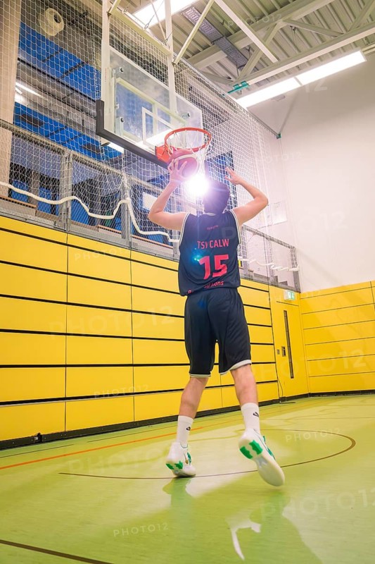 Players throwing a basketball in the sports hall, yellow wall, basketball TSV Calw, Germany