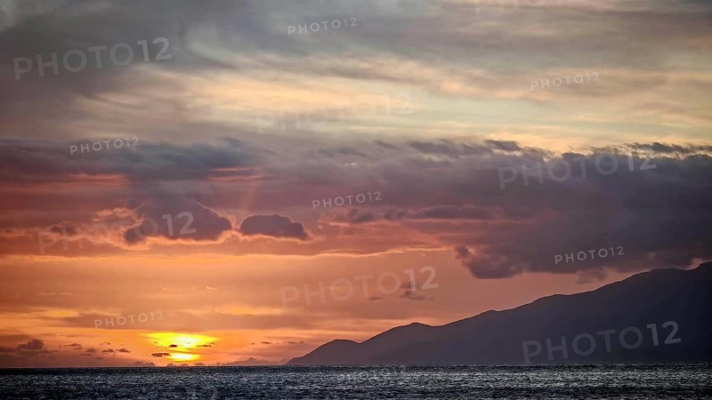 A pastel sunset over the sea and mountains with calm clouds, Mindelo, Sao Vicente, Cabo Verde, Cape Verde, Cape Verde