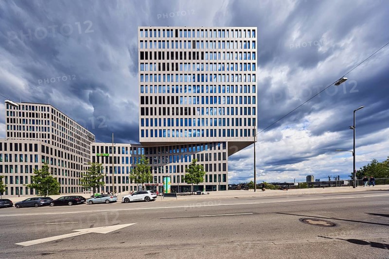 Group headquarters Flix SE, Flixbus, Flixtrain, commercial building, high-rise building, modern architecture, lantern, road marking direction arrow, parking strip with vehicles, city trees, completely overcast cloudy sky, cumulus clouds, dark gray Cumulus congestus clouds, Friedenheimer bridge, Munich, state capital, district-free city, Bavaria, Germany