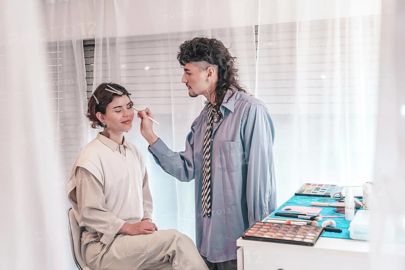Skilled makeup artist carefully applies makeup to a client's face, enhancing their natural beauty with precision and expertise in a professional setting