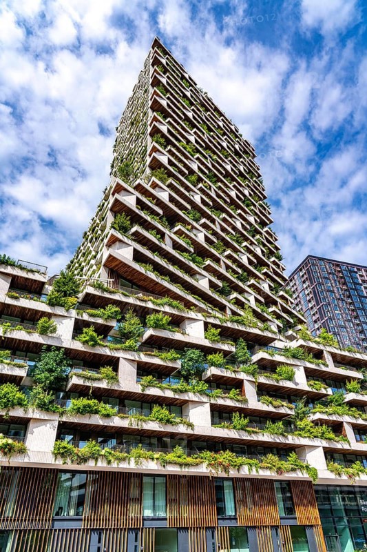 Wonderwoods residential tower, one of 2 green buildings, in Utrecht in the new Healthy Urban Quarter, at the central station, 105 metres high with 30 floors, Tower II, over 360 trees and over 9600 shrubs and flowering plants native to the region, all irrigated with collected rainwater, sponge city principle and monitored with sensors, Utrecht, Netherlands