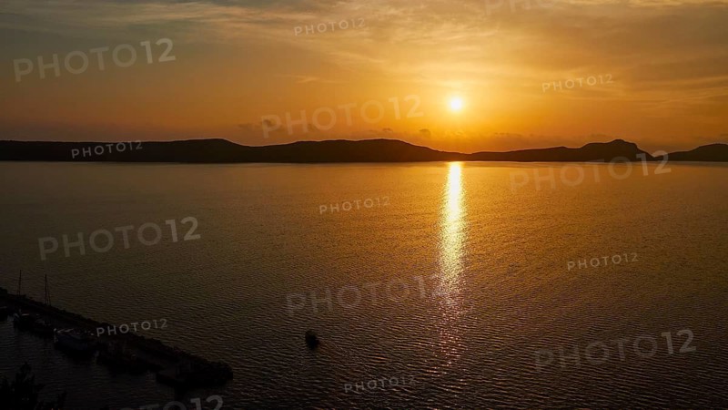 The sunset is reflected in the sea, the landscape can be seen in silhouettes, Navarino Bay, Pylos, Peloponnese, Greece