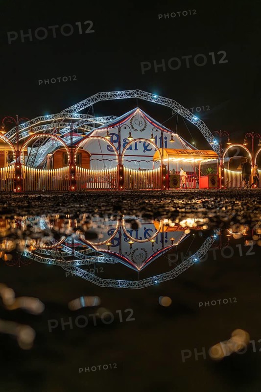 Lights of the circus tent reflected in a puddle at night, Böblingen, Germany
