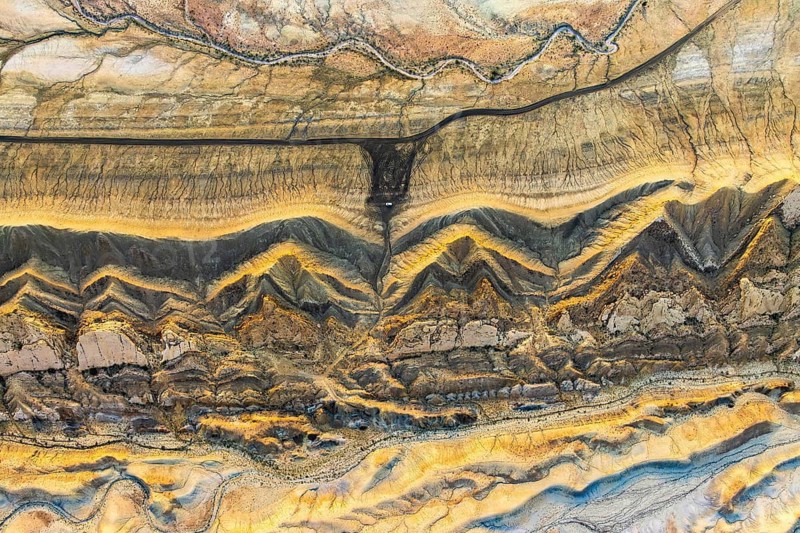 Captivating aerial photo of Utah's golden sandstone desert, showcasing intricate geological patterns and vibrant hues. A stunning natural tapestry from above