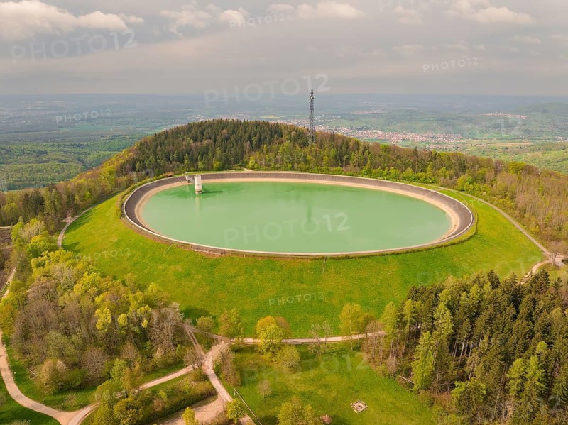 Reservoir on a hill surrounded by forest and meadows with observation tower in the background, Glems reservoir, Upper reservoir basin, Swabian Alb, Germany