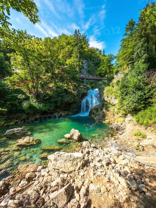 Turquoise water flows under a wooden bridge at the bottom of tolmin gorge in triglav national park, slovenia