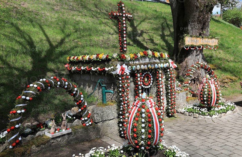 Osterbrunnen, Franconian Switzerland, here in Tiefenpölz near Heiligenstadt, Bamberg district, Upper Franconia, Bavaria, Germany, A richly decorated sanctuary with Easter eggs and a cross in a spring-like setting