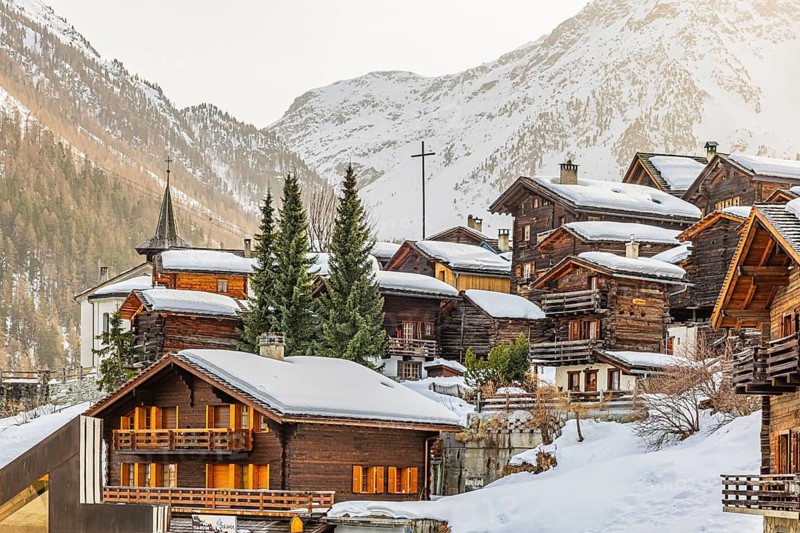 Snow-covered old farmhouses, large wooden cross, historic town center, Grimentz, Val d'Anniviers, Valais Alps, Canton of Valais, Switzerland