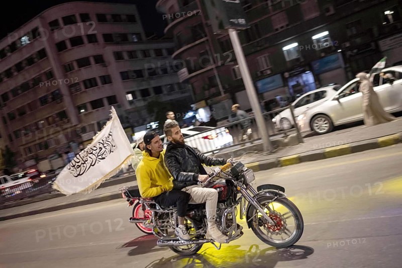 Damascus, Syria. December 7th 2025. Syrians on a motorcycle with an Islamic flag ride in celebration of one year since the fall of the Assad regime, Damascus, Syria