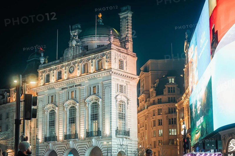 Illuminated historic buildings with large display board at night in London, New Year's Eve London, United Kingdom