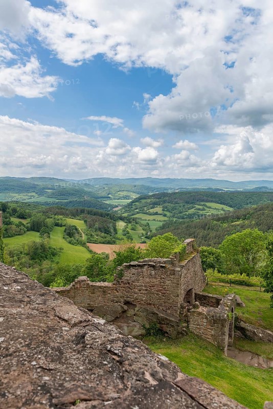 View from the medieval castle ruin Hanstein to the youth castle Ludwigstein and the wooded low mountain range landscape, ruin on red sandstone rocks, fields, Bornhagen, district Eichsfeld, Thuringia, Germany
