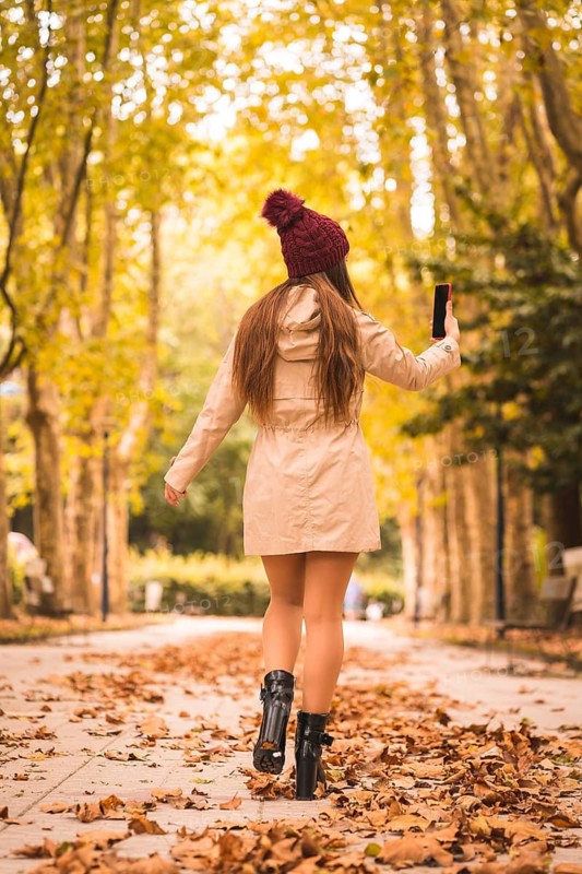 Portrait of a beautiful woman in autumn next to a forest in nature